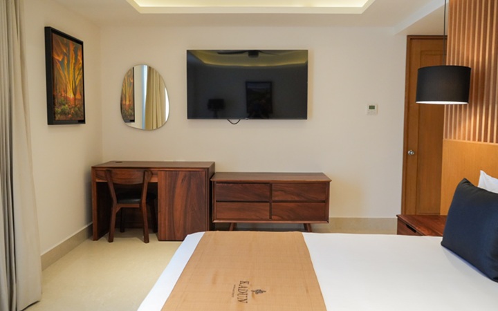 Espacio de trabajo moderno dentro del Scenic Studio que cuenta con un escritorio de trabajo minimalista, una smart TV y un elegante espejo decorativo en Kadun Hotel Boutique.