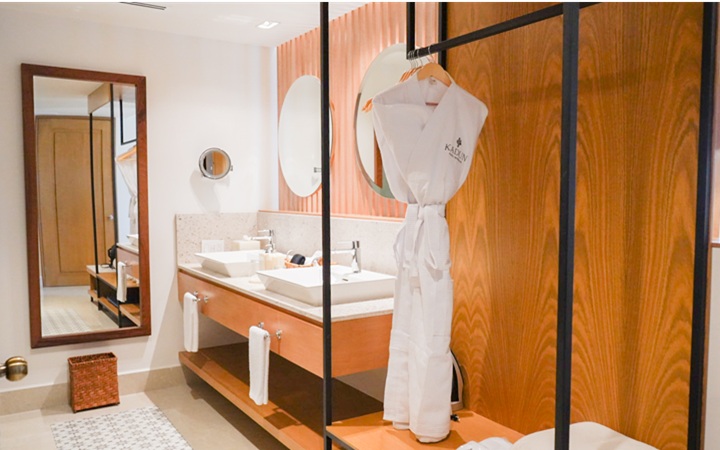 Distribución sofisticada de la suite Scenic Studio que muestra un estilizado espejo de cuerpo entero, armario minimalista moderno y acabados de lujo a la medida en Kadun Hotel Boutique.