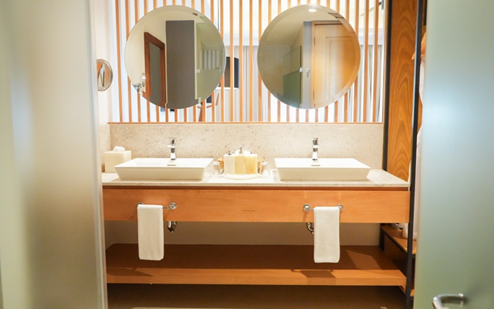 Elegante diseño de baño de lujo que muestra tocadores con lavabos dobles independientes con amenidades de baño premium en Kadun Hotel Boutique.