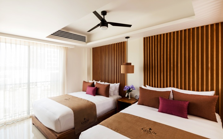 Elegante interior de la habitación Studio con una lujosa cama doble, muebles a la medida y balcón privado con vistas al centro de Cabo San Lucas en Kadun Hotel Boutique.