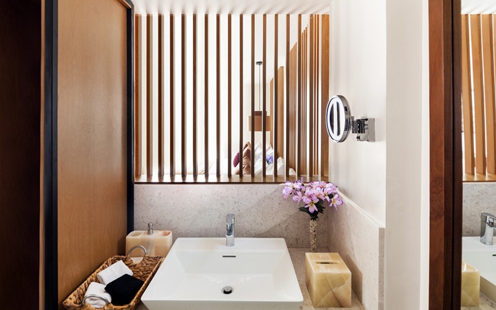 Diseño de baño moderno y lujoso que incluye un tocador con lavabo independiente junto a amenidades boutique de calidad premium en Kadun Hotel Boutique.