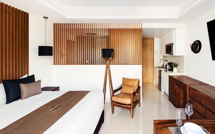 Vista panorámica de la suite Studio de lujo que cuenta con una kitchenette totalmente equipada, mesa de comedor, una confortable cama King-size y un escritorio de trabajo exclusivo con silla en Kadun Hotel Boutique.