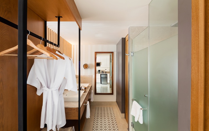 Baño de la suite de lujo que muestra una distribución de tres piezas con lavabos dobles independientes, una cabina de ducha de cristal y un sanitario aislado en Kadun Hotel Boutique.