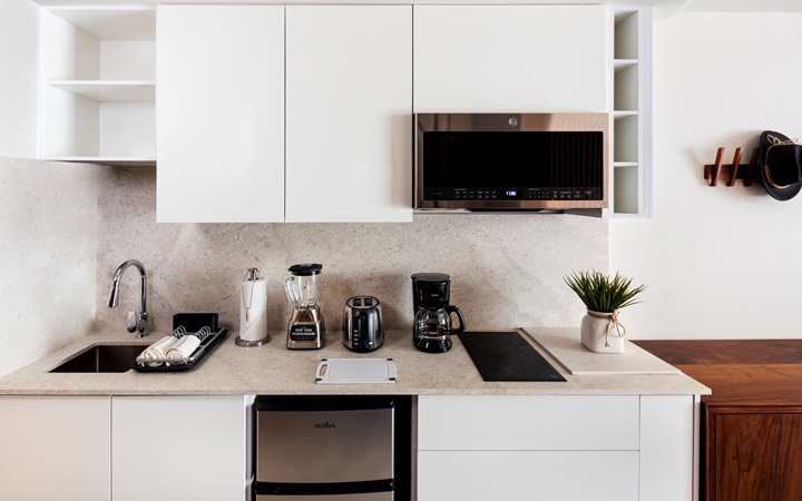 Kitchenette de lujo totalmente equipada dentro de la suite studio, con gabinetes modernos y estilizados, electrodomésticos integrados de calidad premium y una encimera de mármol en Kadun Hotel Boutique.
